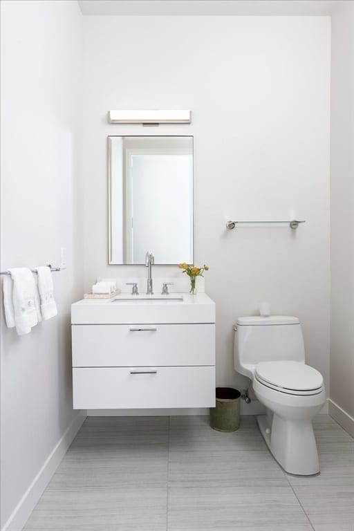 bathroom featuring toilet, tile floors, and vanity