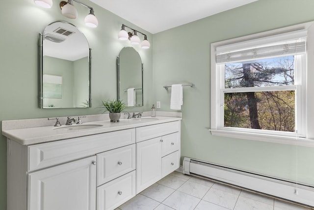 bathroom featuring double vanity, a baseboard heating unit, plenty of natural light, and a sink