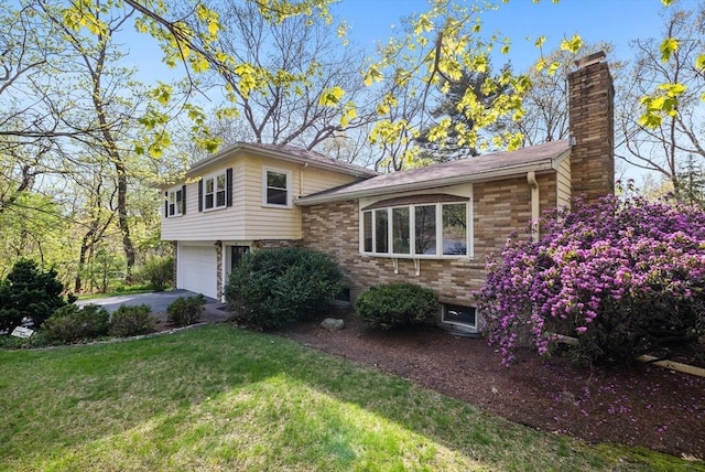 tri-level home with an attached garage, a front lawn, driveway, and a chimney