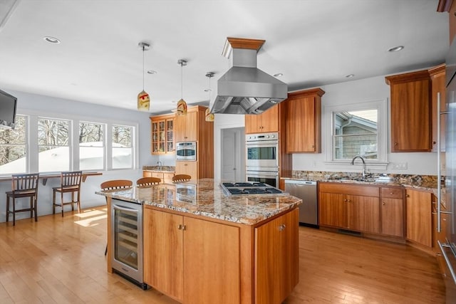 kitchen featuring wine cooler, stainless steel appliances, a kitchen island, brown cabinets, and island exhaust hood