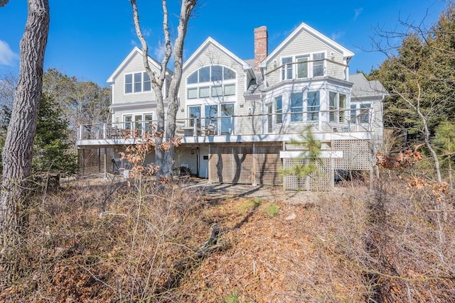 rear view of property with a chimney and a deck