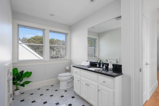 bathroom with visible vents, toilet, vanity, and baseboards