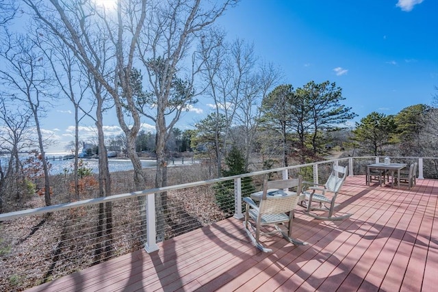 wooden deck featuring outdoor dining area and a water view