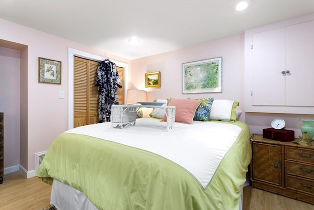 bedroom with light wood-style flooring, a closet, recessed lighting, and baseboards
