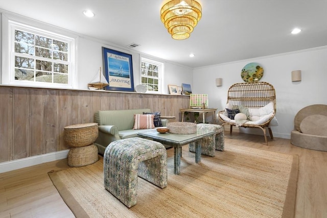 living area with wood finished floors, crown molding, recessed lighting, and baseboards