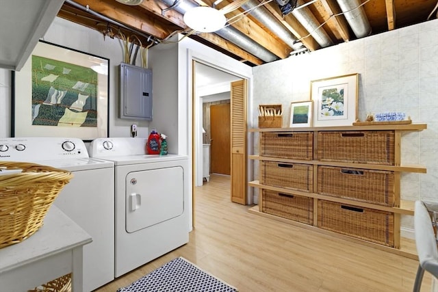 laundry room featuring independent washer and dryer, electric panel, and light wood-style floors