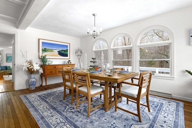 dining area featuring healthy amount of natural light, a chandelier, and hardwood / wood-style flooring