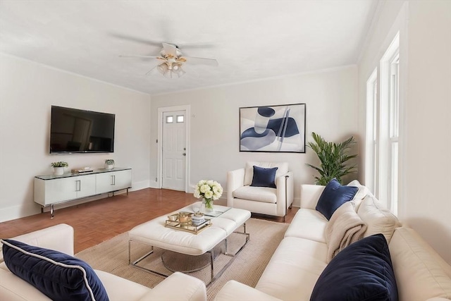 living area featuring baseboards and a ceiling fan