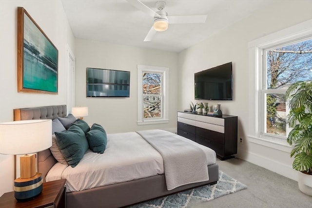 bedroom with light carpet, baseboards, and a ceiling fan