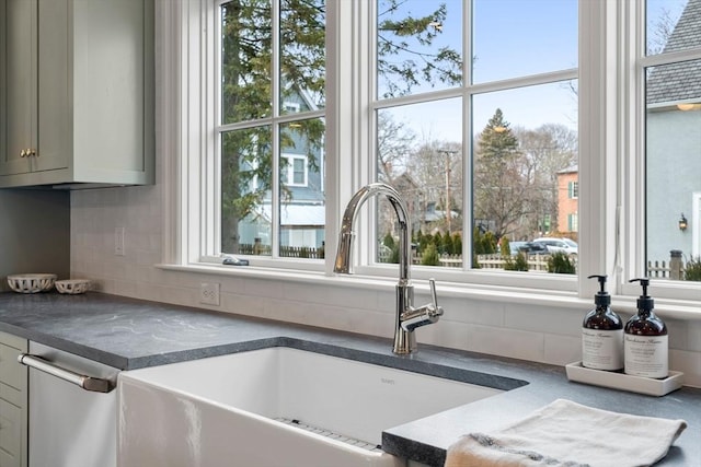 room details featuring backsplash, gray cabinetry, and sink