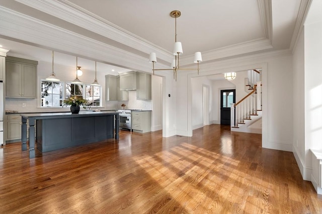 living room with an inviting chandelier, wood-type flooring, and ornamental molding