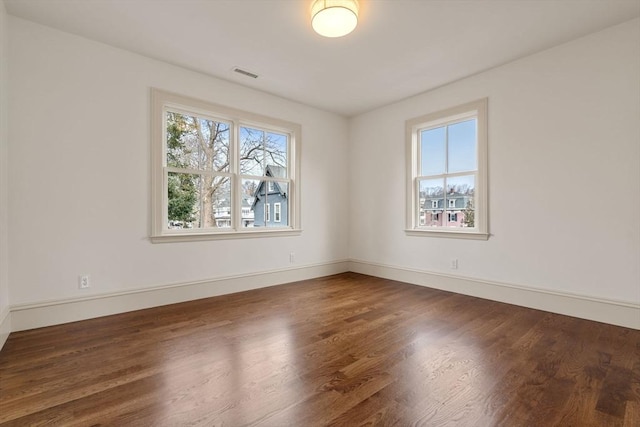 unfurnished room with dark wood-type flooring