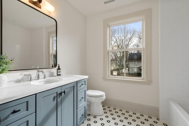 bathroom with vanity, toilet, and a tub