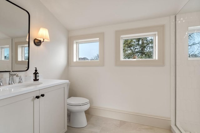 bathroom featuring vanity, toilet, walk in shower, and vaulted ceiling