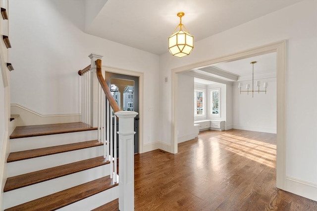 entryway with hardwood / wood-style flooring and a notable chandelier