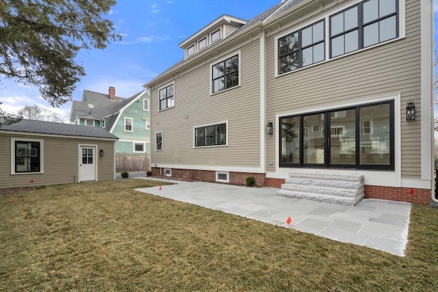 back of property featuring a patio area and a yard