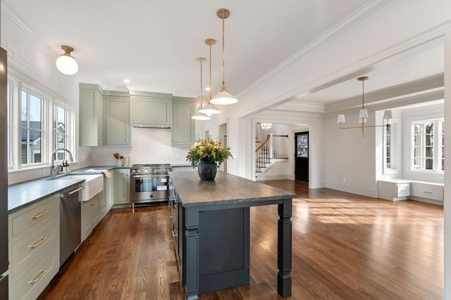 kitchen featuring a center island, stainless steel appliances, decorative light fixtures, and sink