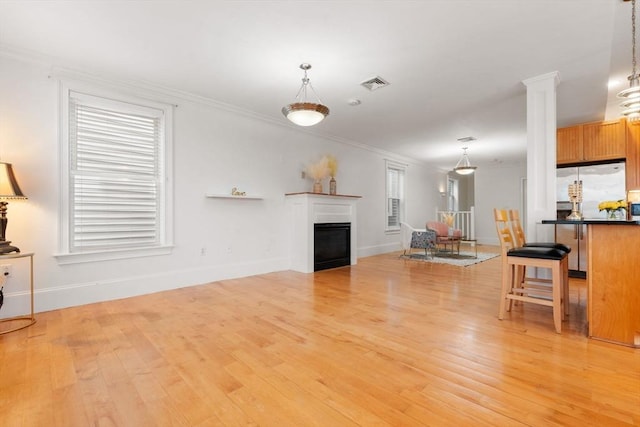 714 E 4th St Unit 3, Boston, MA 02127 - living room with light wood-style floors, crown molding, ornate columns, baseboards, and a fireplace