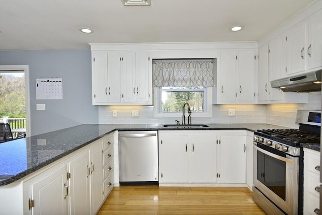 231 Mattapoisett Rd, Acushnet, MA 02743 - kitchen with appliances with stainless steel finishes, a sink, white cabinets, dark stone counters, and under cabinet range hood