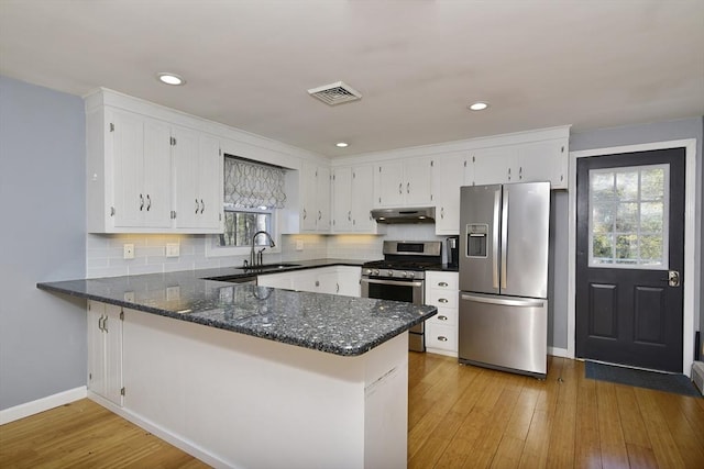 231 Mattapoisett Rd, Acushnet, MA 02743 - kitchen featuring visible vents, a peninsula, under cabinet range hood, a sink, and stainless steel appliances