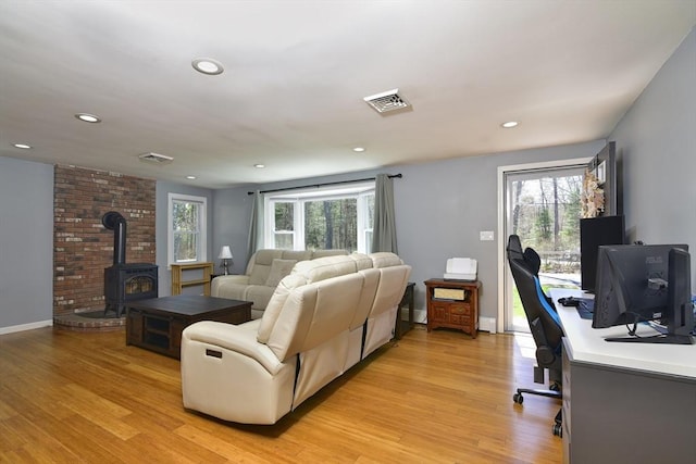 231 Mattapoisett Rd, Acushnet, MA 02743 - living room with a wealth of natural light, a wood stove, light wood-style flooring, and visible vents
