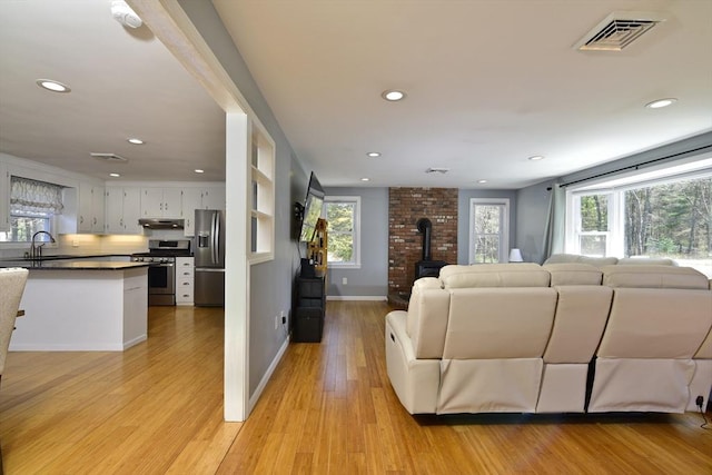 231 Mattapoisett Rd, Acushnet, MA 02743 - living room featuring a wood stove, recessed lighting, light wood-style flooring, and visible vents