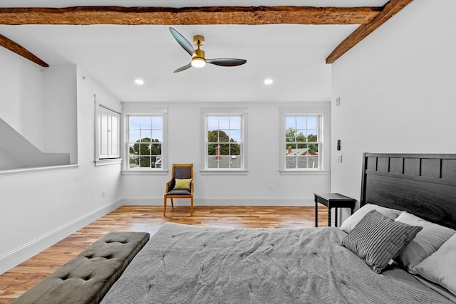 bedroom with beamed ceiling, ceiling fan, and light wood-type flooring