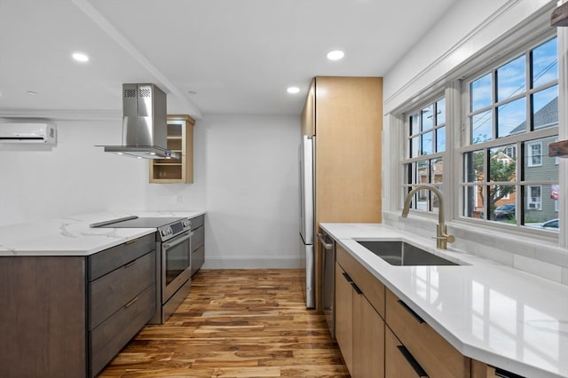 kitchen with sink, wall chimney range hood, dark hardwood / wood-style floors, a wall mounted AC, and appliances with stainless steel finishes