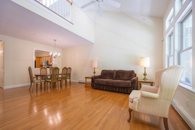 116 Spring Mdw Unit 116, Hanover, MA 02339 - living area with light wood-type flooring, ceiling fan, baseboard heating, a chandelier, and baseboards