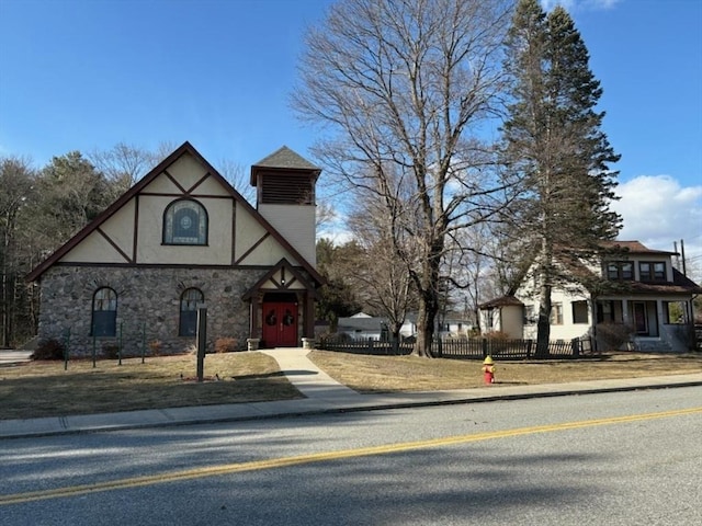 tudor-style house featuring stone siding and stucco siding