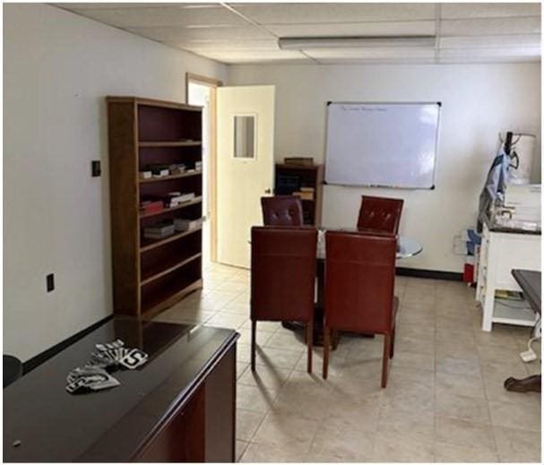 home office with a paneled ceiling and light tile patterned flooring