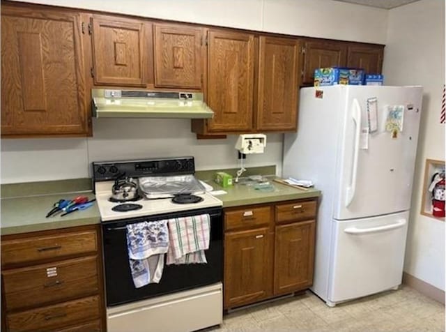 kitchen with range with electric stovetop, under cabinet range hood, freestanding refrigerator, light countertops, and brown cabinets