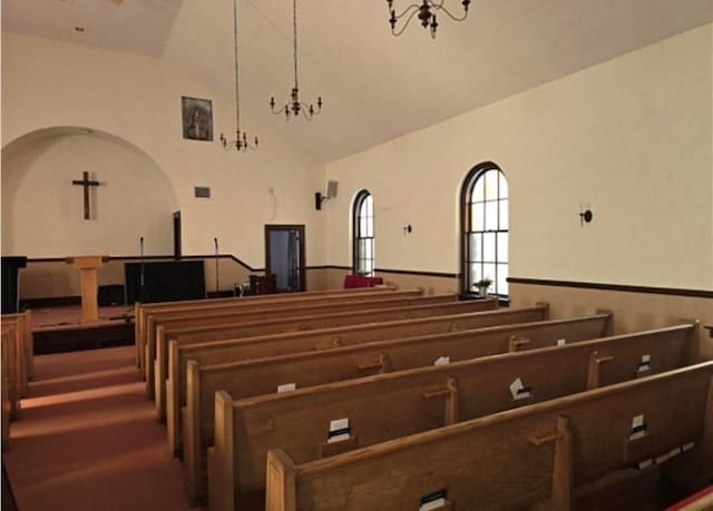 miscellaneous room featuring a chandelier and high vaulted ceiling