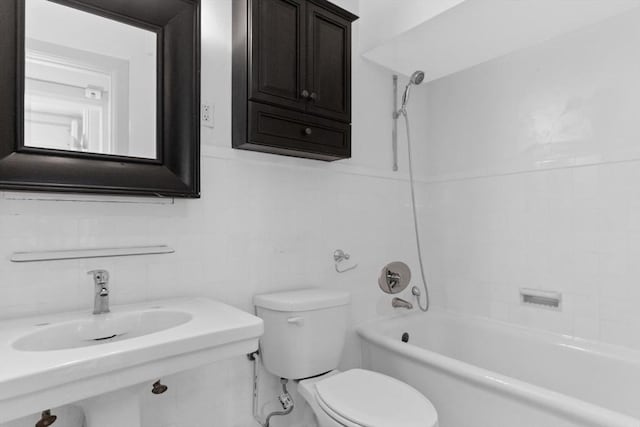 full bathroom featuring tub / shower combination, a sink, toilet, and tile walls