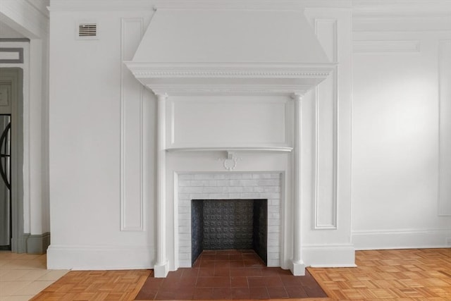 room details featuring a brick fireplace, visible vents, and baseboards