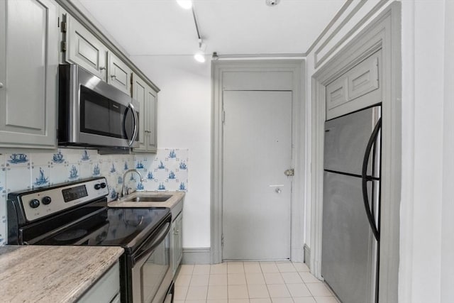 kitchen featuring tasteful backsplash, appliances with stainless steel finishes, gray cabinets, and a sink