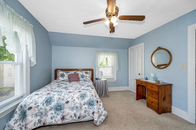 carpeted bedroom featuring vaulted ceiling, baseboards, and a ceiling fan