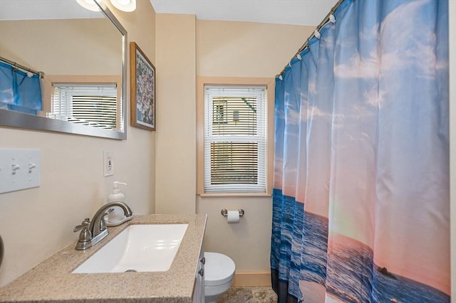 full bathroom featuring toilet, vanity, curtained shower, and baseboards