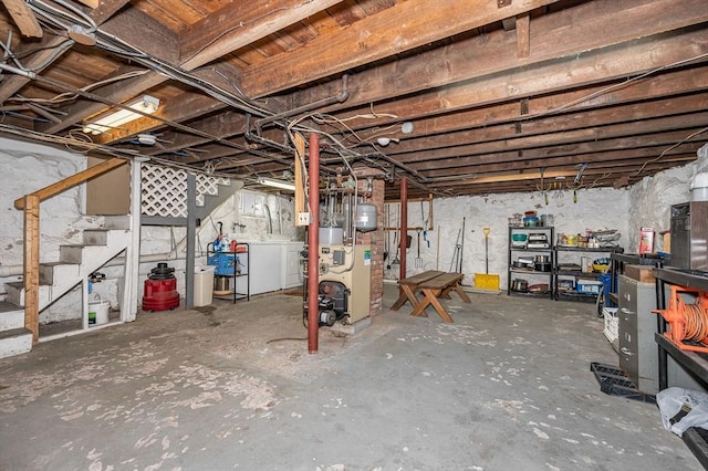 unfinished basement featuring washer and dryer, stairway, and a heating unit