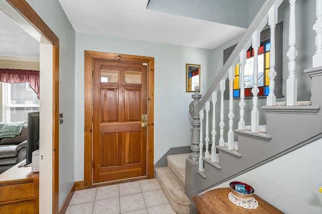 foyer entrance featuring stairway, baseboards, and tile patterned floors