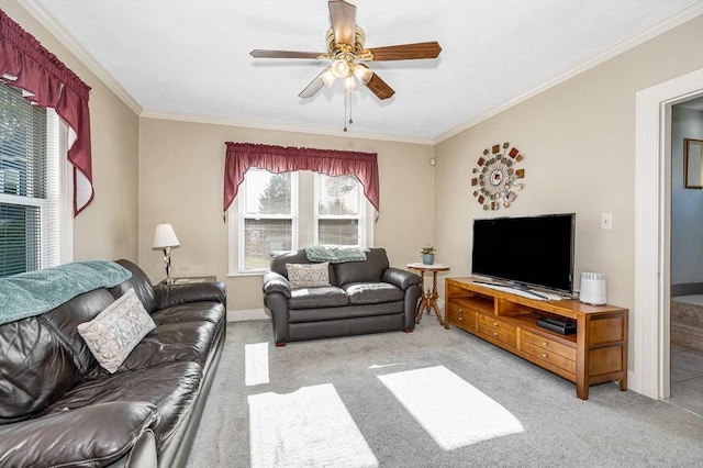 carpeted living area featuring plenty of natural light, ornamental molding, ceiling fan, and baseboards