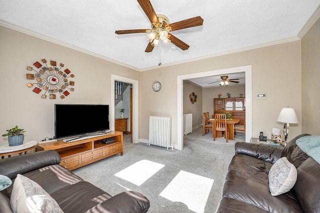 living room with radiator, a ceiling fan, ornamental molding, light carpet, and baseboards