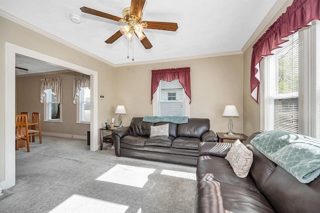 carpeted living room featuring a ceiling fan, ornamental molding, and baseboards