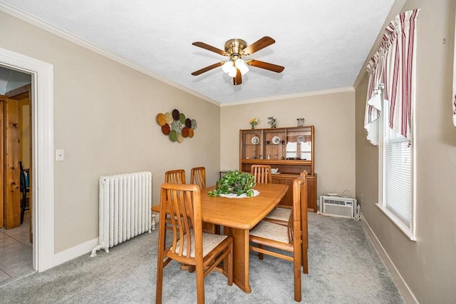 dining room featuring radiator, a ceiling fan, ornamental molding, baseboards, and carpet