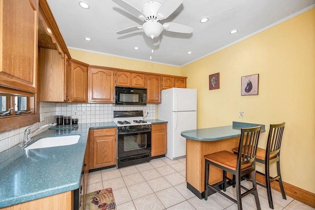 kitchen featuring black microwave, gas range, freestanding refrigerator, a sink, and backsplash