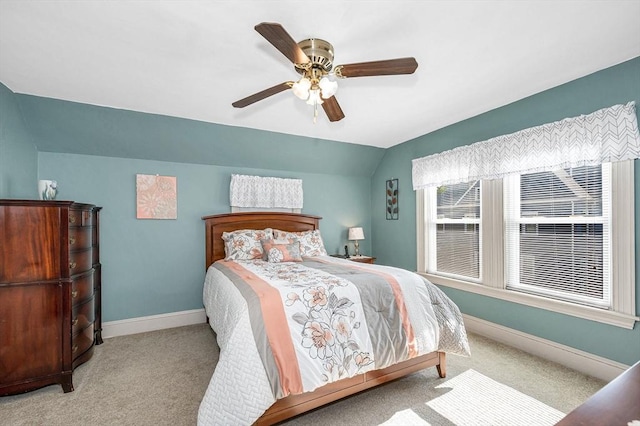 carpeted bedroom with baseboards, vaulted ceiling, and a ceiling fan