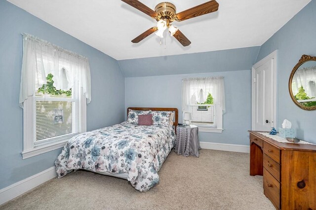 bedroom featuring lofted ceiling, light colored carpet, baseboards, and ceiling fan