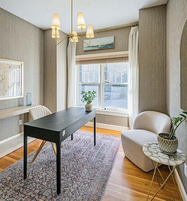 office area featuring wallpapered walls, a notable chandelier, baseboards, and wood finished floors