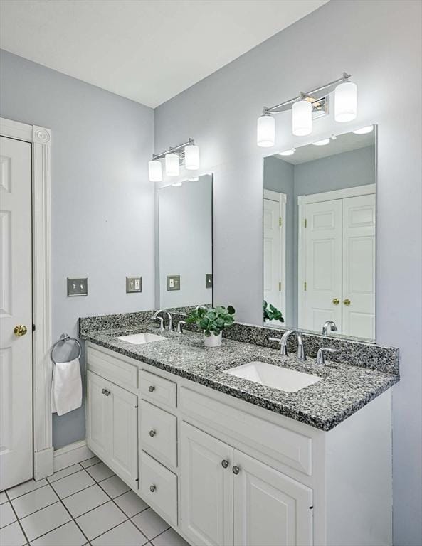 bathroom with double vanity, tile patterned flooring, and a sink