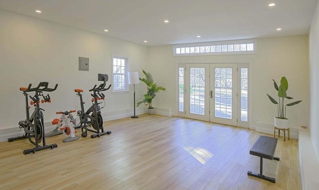 workout area with recessed lighting and light wood finished floors